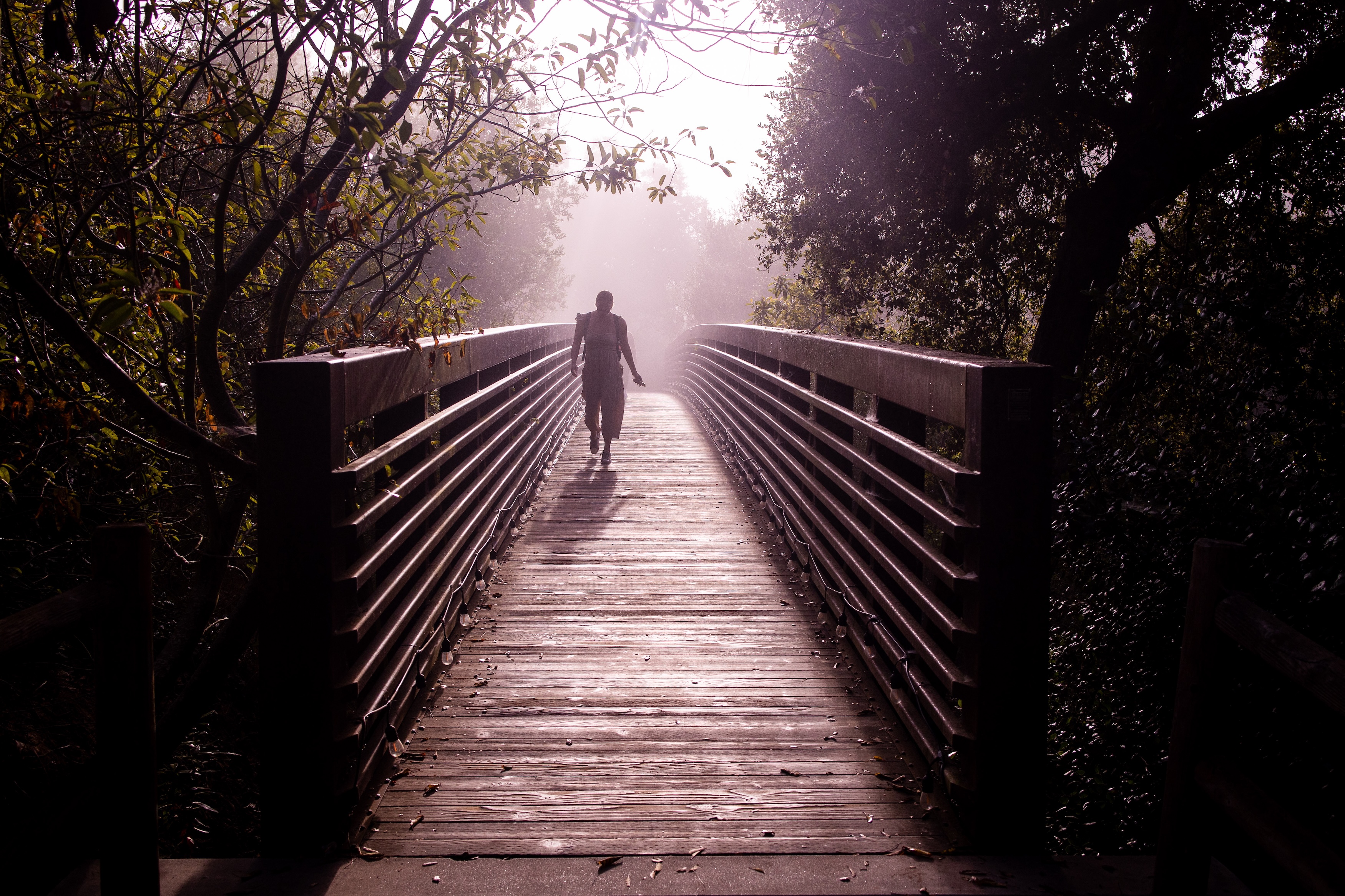 woman walking across westmont bridge in fog